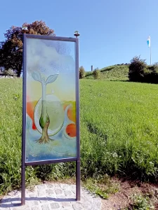 Ein Glaskunstobjekt zeigt eine menschlich anmutende Pflanze die in Wasser wurzelt. 