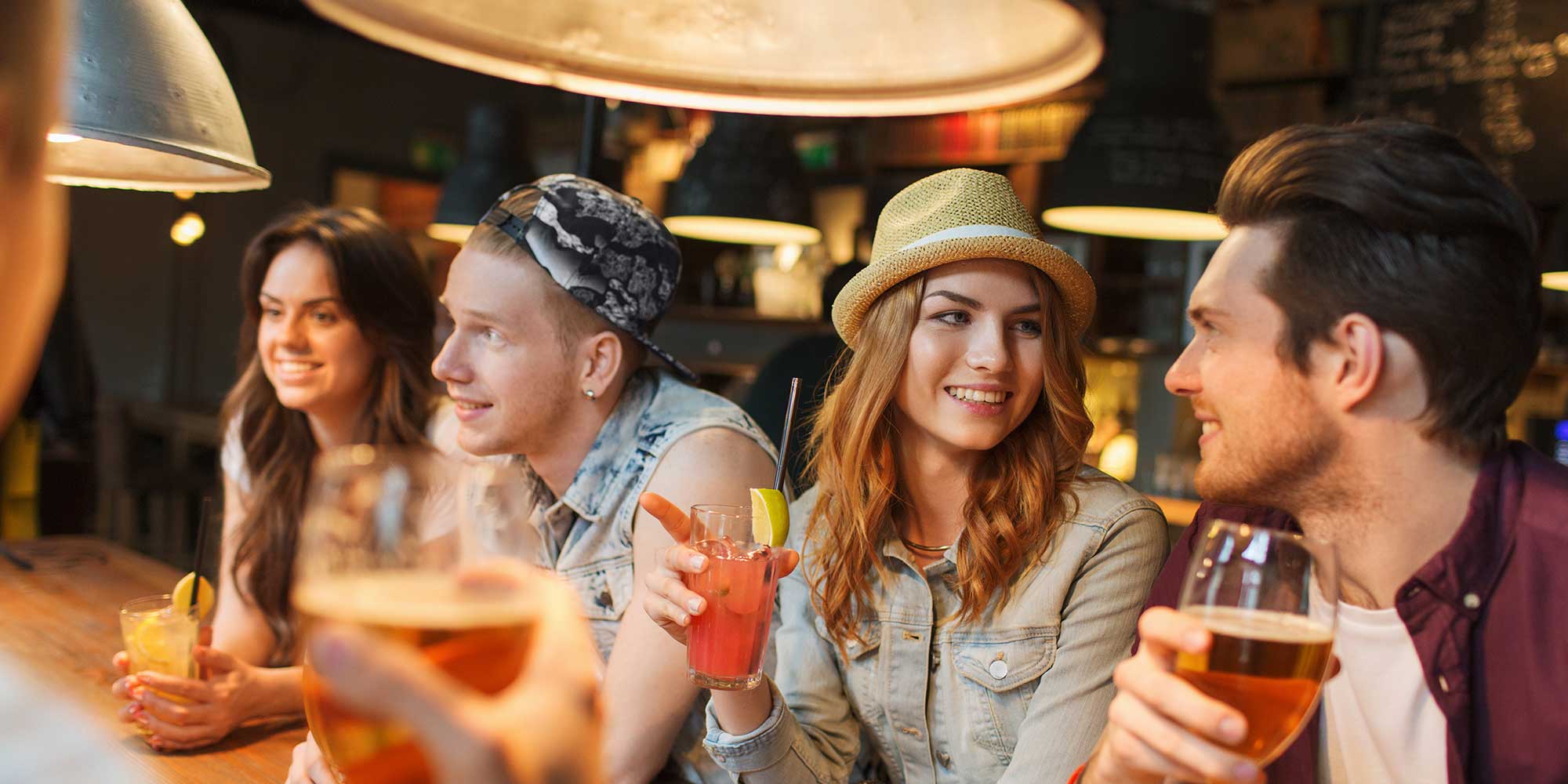 Gruppe junger Menschen trinken Cocktails an einer Bar