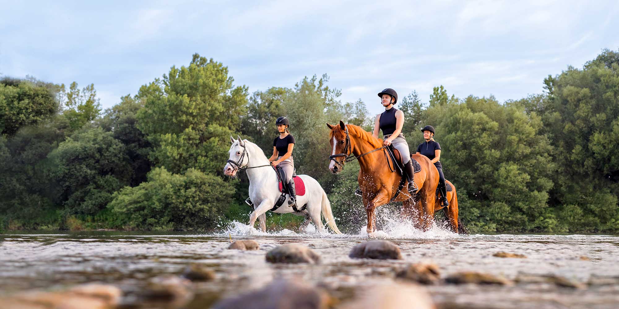 Reiterinnen durchqueren einen Fluß